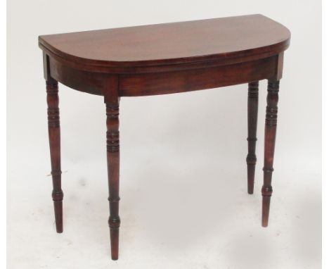 A late George III mahogany demi-lune card table raised on ring turned tapering legs to peg feet, width 91cm.