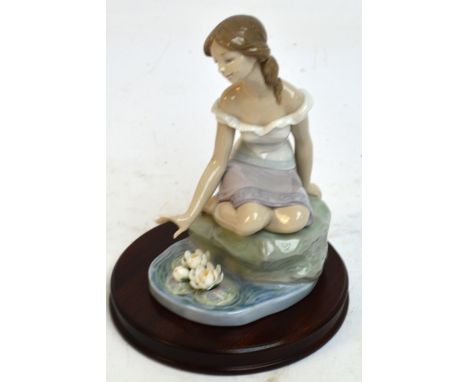 A boxed Lladro figure; 7706 "Reflections of Helena", with stand. CONDITION REPORT: A few petals are missing, otherwise appear