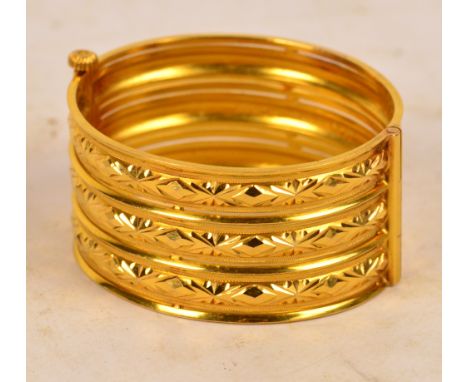A Chinese yellow metal bangle with screw clasp and three raised pierced bands, length approx 6cm, approx 51.5g, bears indisti