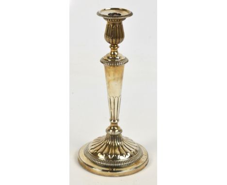 A George III hallmarked silver gadrooned decorated candlestick of tapering form with bell shaped sconce, raised on spreading 