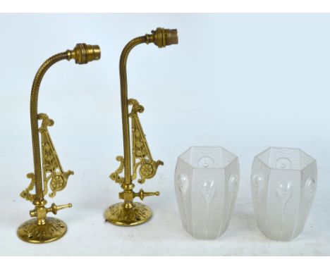 A pair of Edwardian brass wall light fittings with decorated brackets and hexagonal Art Nouveau part etched drop pattern glas