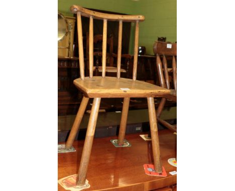 A 19th century child's ash and elm primitive stick back chair, with curved top rail above a curved seat with four pegged legs