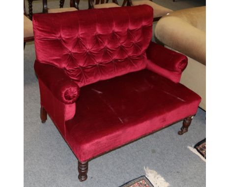 A small button back settee upholstered in red velvet