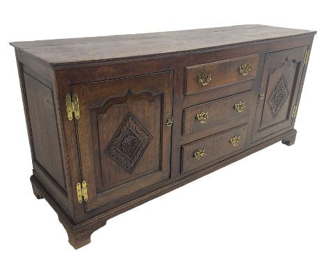 George III oak dresser base, fitted with three graduating central drawers, flanked by two arched fielded panel doors, the fac