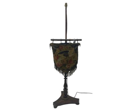 Victorian rosewood pole screen converted to standard lamp, turned column on a triform platform base with compressed bun feet,