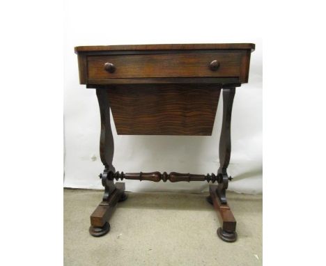 An early Victorian rosewood work table with a long drawer over a sliding wool well, vase shaped ends and turned stretcher, on