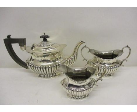 An Edwardian silver matching three piece teaset by Robert Chandler, Birmingham 1903-1906, of shaped demi reeded form, compris