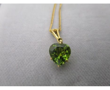 A Mappin &amp; Webb 18ct gold pendant set with a heart shaped peridot, the suspension ring, set with a diamond, on a fine cha