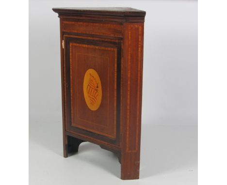 A late 19th Century inlaid mahogany Corner Cabinet, with crossbanded top and sides, the large panel door decorated with large