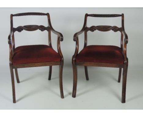 A pair of early 19th Century Regency Carver Armchairs, with carved back rail and panel, and with inset upholstered seats. (2)
