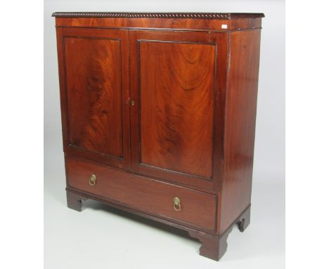 A Nelson period figured mahogany Blanket Press, with roped edge on top over two panel doors, a base drawer and bracket feet, 