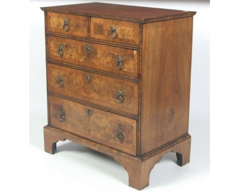 A small George II style inlaid figured walnut Chest, of two short and three long drawers, the top and drawer fronts with wide