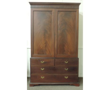 A large Irish Georgian mahogany Linen Press, the chequered cornice over two large panel doors, on base with two short and two