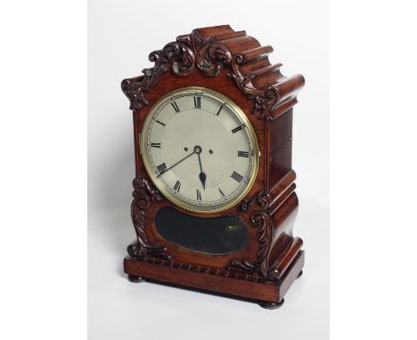 An impressive large English Regency rosewood Bracket Clock, the carved pediment over a large silvered dial with Roman numeral