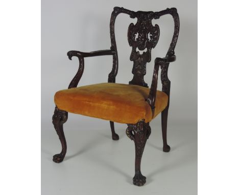 An extremely fine and elaborately carved mahogany and parcel gilt Armchair, in the early George III style, the shaped back wi