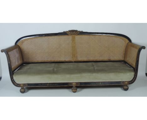 An important and unusual Irish Regency period large ebonised Settee, the carved and painted giltwood rail with an oval panel 