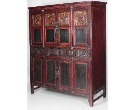 A large 20th Century Chinese red lacquered Cabinet, with carved and painted  panel doors, highlighted in gilt and Chinese scr