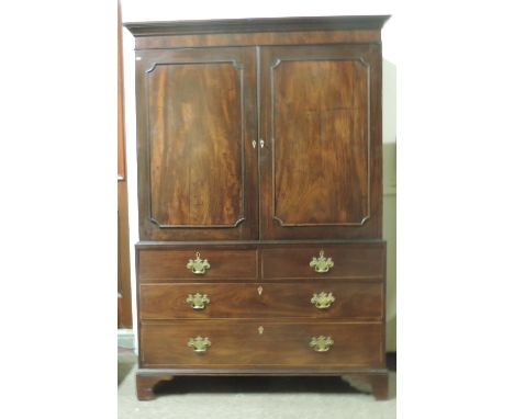 An attractive Georgian mahogany Gentlemans Wardrobe of small proportions, the moulded cornice over two figured panel doors, o