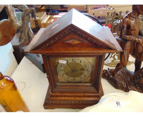 A wooden and brass mantle clock