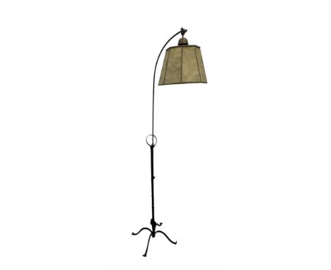 Early 20th century wrought iron standard lamp, the arched arm with adjustable height supporting a stitched hide shade, raised