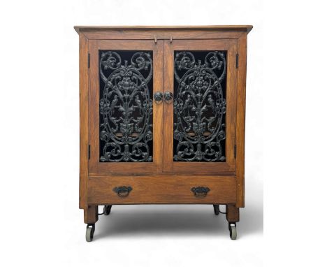 Mid-20th century Eastern hardwood and cast iron side cabinet, rectangular top over twin cast iron doors with pierced floral a
