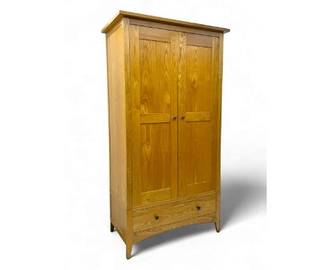 Contemporary light oak double wardrobe, projecting cornice over two panelled doors enclosing hanging rail and shelf, above fu
