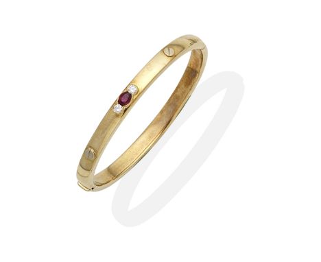 RUBY AND DIAMOND-SET BANGLEThe hinged bangle set with an oval-cut ruby and brilliant-cut diamonds, with nail head motifs, inn