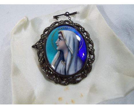 A hand-painted enamelled brooch depicting Mary the mother of Jesus set in a white metal surround with semi precious stone det