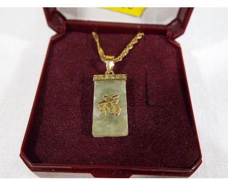 A lady's 9 carat gold necklace and jade pendant with 9 carat gold detailing, approximate weight 3.33 grams, boxed