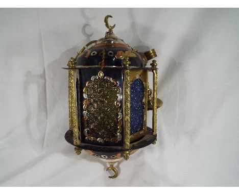 An unusual Middle Eastern metal and glass ceiling lamp with ornate decorated columns and multi-coloured molded glass panels c