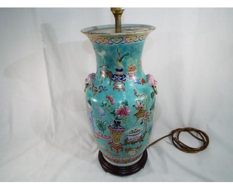 A large 19th century Chinese Famille rose Precious Objects vase with mask handles and decorated with precious objects, on woo