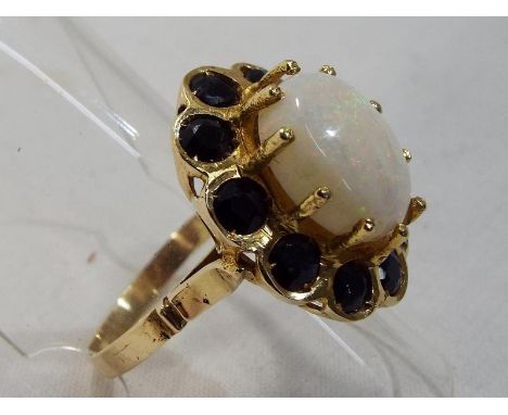 A lady's hallmarked (rubbed) probably 14 ct gold cluster ring set with white opal approx 1cm surrounded by ten Australian sap