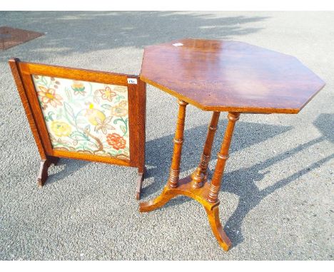 An octagonal table on a tripod stand on turned legs, 74cm x 55cm x 55cm and an oak firescreen with embroidered floral decorat