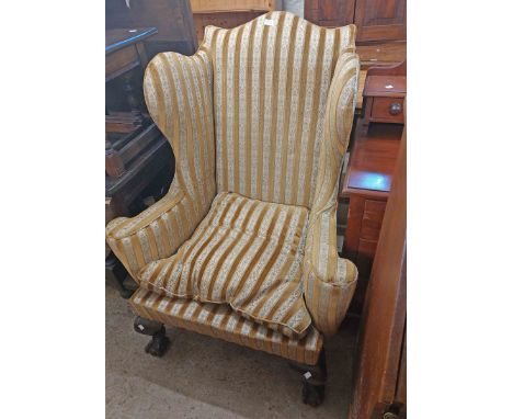 An antique Georgian style wingback armchair with striped gold velour and tapestry upholstery, set on heavy cabriole front leg