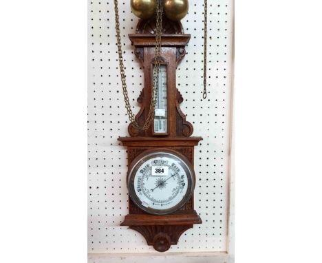 An early 20th Century stained oak framed barometer/thermometer with aneroid works