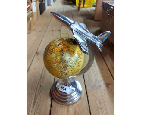 A modern Art Deco style revolving globe of the world with polished metal frame and aeroplane finial