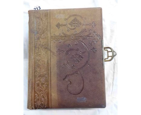 An old leather bound family photograph album with internal litho-print decorated mounts