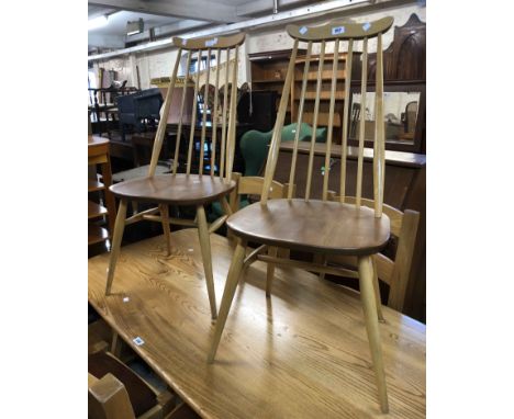 A pair of Ercol elm and ash stick back dining chairs with moulded solid seats, set on slender turned supports