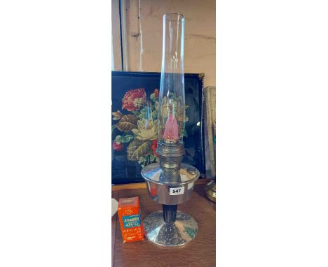 A vintage Aladdin oil lamp with chrome plated reservoir and clear glass shade - sold with an extra mantle and operating instr