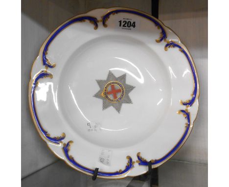 A Victoria Coalport bone china soup plate from the Order of the Garter service, the borders with Rococo scroll decoration and