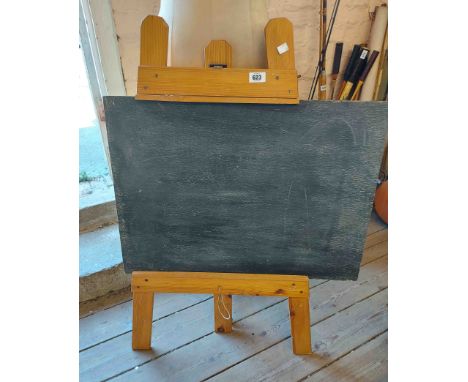 A vintage child's wooden blackboard set on a pine easel
