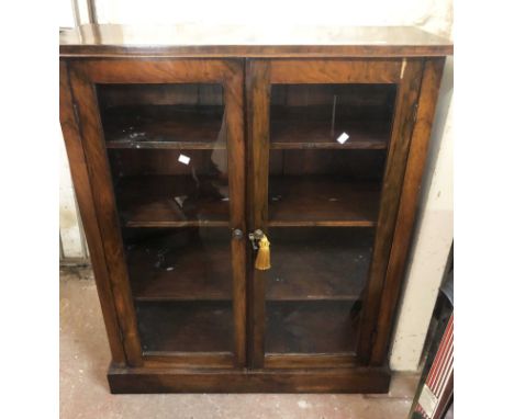 A 90cm Victorian rosewood book cabinet with shelves enclosed by a pair of glazed panel doors, set on plinth base - minor vene