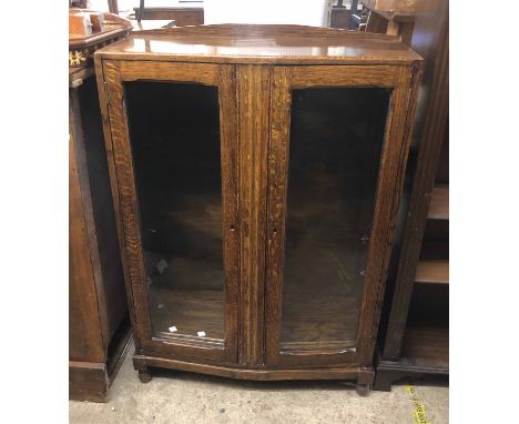 A 75cm vintage polished oak display cabinet enclosed by a pair of glazed panel doors