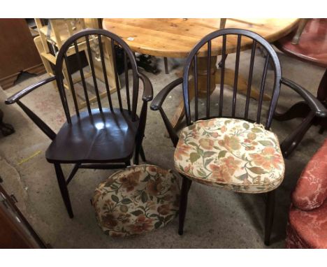 A pair of Ercol dark stained elm hoop stick back elbow chairs, set on tapered supports