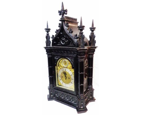 A late 19th Century Gothic Revival ornate ebonised cased table clock of architectural design with regulator to the silvered a