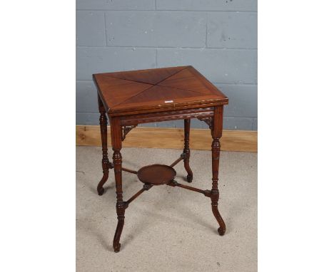 Edwardian mahogany envelope top card table, the quartered folding top opening to reveal a green baize lined writing surface a