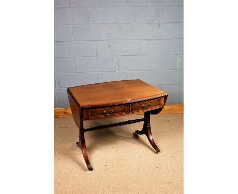 Edwardian mahogany and crossbanded sofa table, the oval top with two drop leaves above two frieze drawers, raised on reeded t