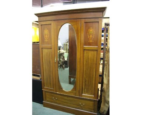 Edwardian mahogany and marquetry inlaid wardrobe, the dentil inlaid pediment above an oval bevelled mirror door flanked by ma