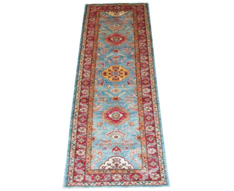 FINE KAZAK RUNNER, 221cm x 83cm, row of medallions on aquamarine field within ruby field. 