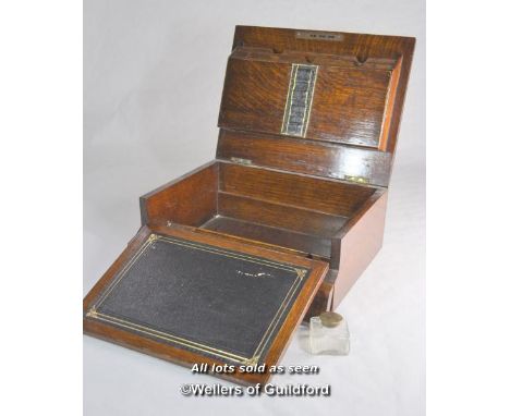 An Edwardian oak lap desk with inset brass handle monogrammed GWB and dated Jan 27 1904, the lifting lid opening to reveal le